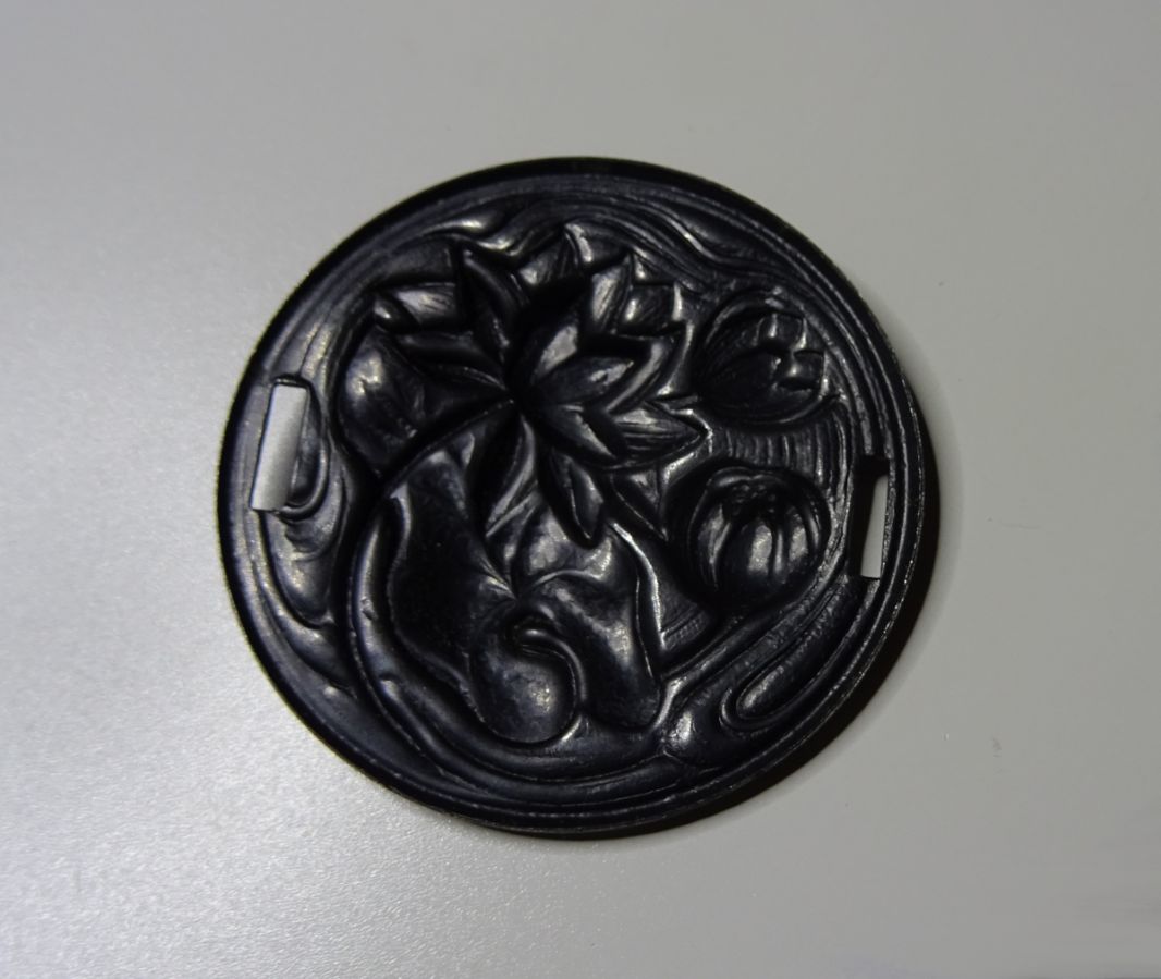 Water lily medallion in black metal relief with side ties 