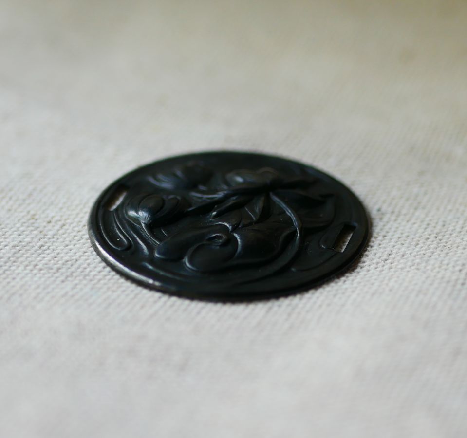 Water lily medallion in black metal relief with side ties 