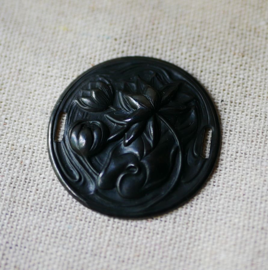 Water lily medallion in black metal relief with side ties 